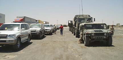 [Convoy of vehicles including a Humvee, military trucks and SUVs]